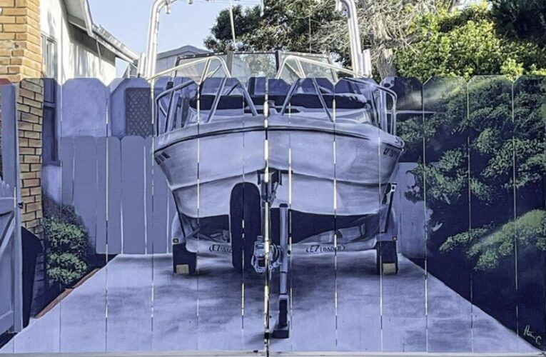 Ordered to put his boat behind a fence, he added a mural that’ll make you do a double take