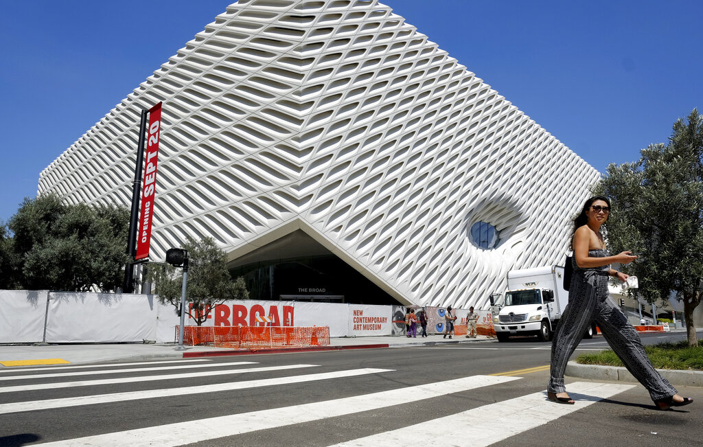 A pedestrian walking past the Broad Museum in downtown Los Angeles. Billionaire philanthropist Eli Broad gives his latest gift to Los Angeles when The Broad, a $140 million museum built to hold some of the greatest pop-art works ever created, opens on Sept. 20, in center. Located across the street from the city's Museum of Contemporary Art and next door to its Walt Disney Concert Hall,The Broad contains some 2,000 pieces from its founder's personal collection. (AP Photo/Richard Vogel)