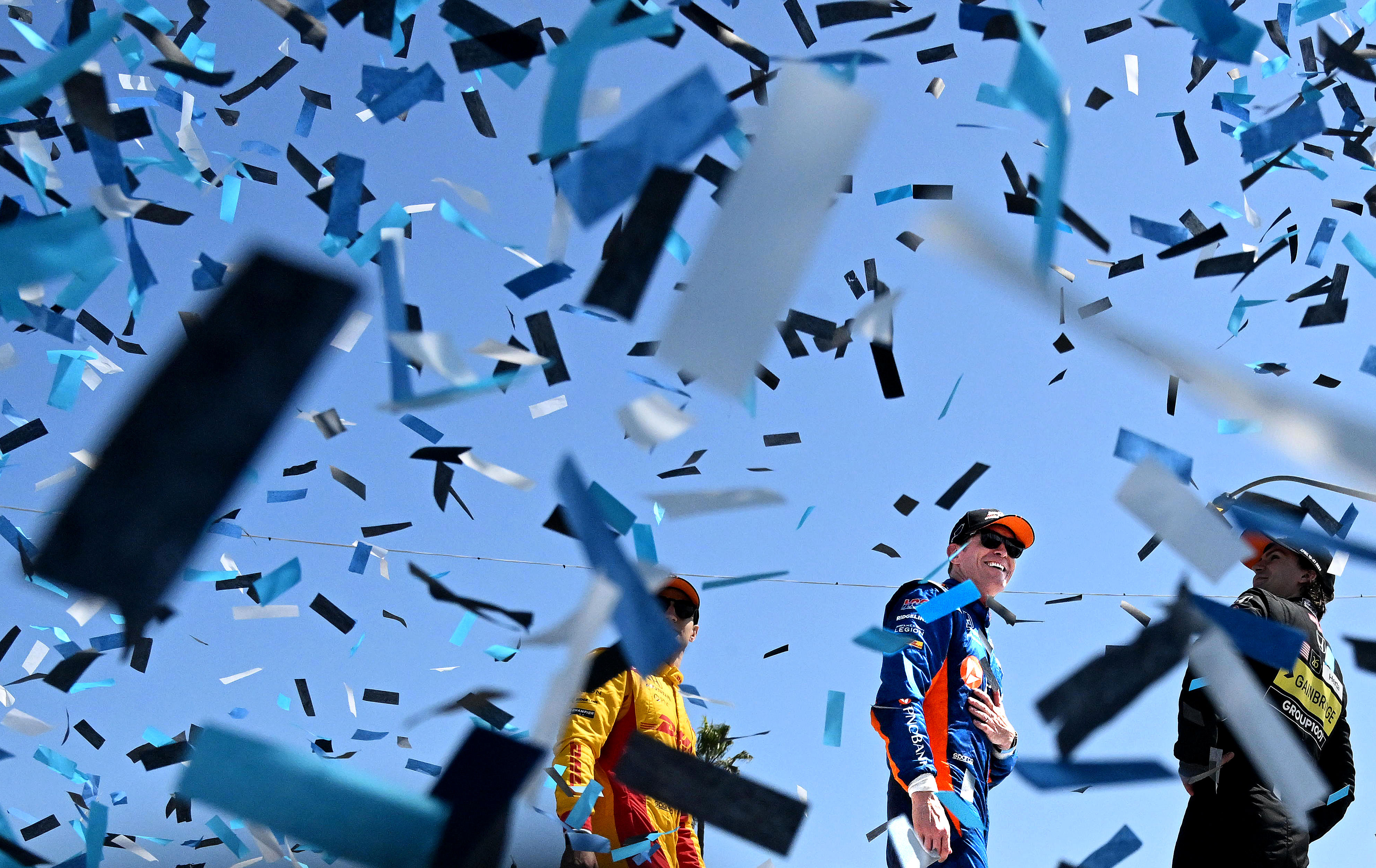 IndyCar driver Scott Dixon, center, smiles as he celebrates his...