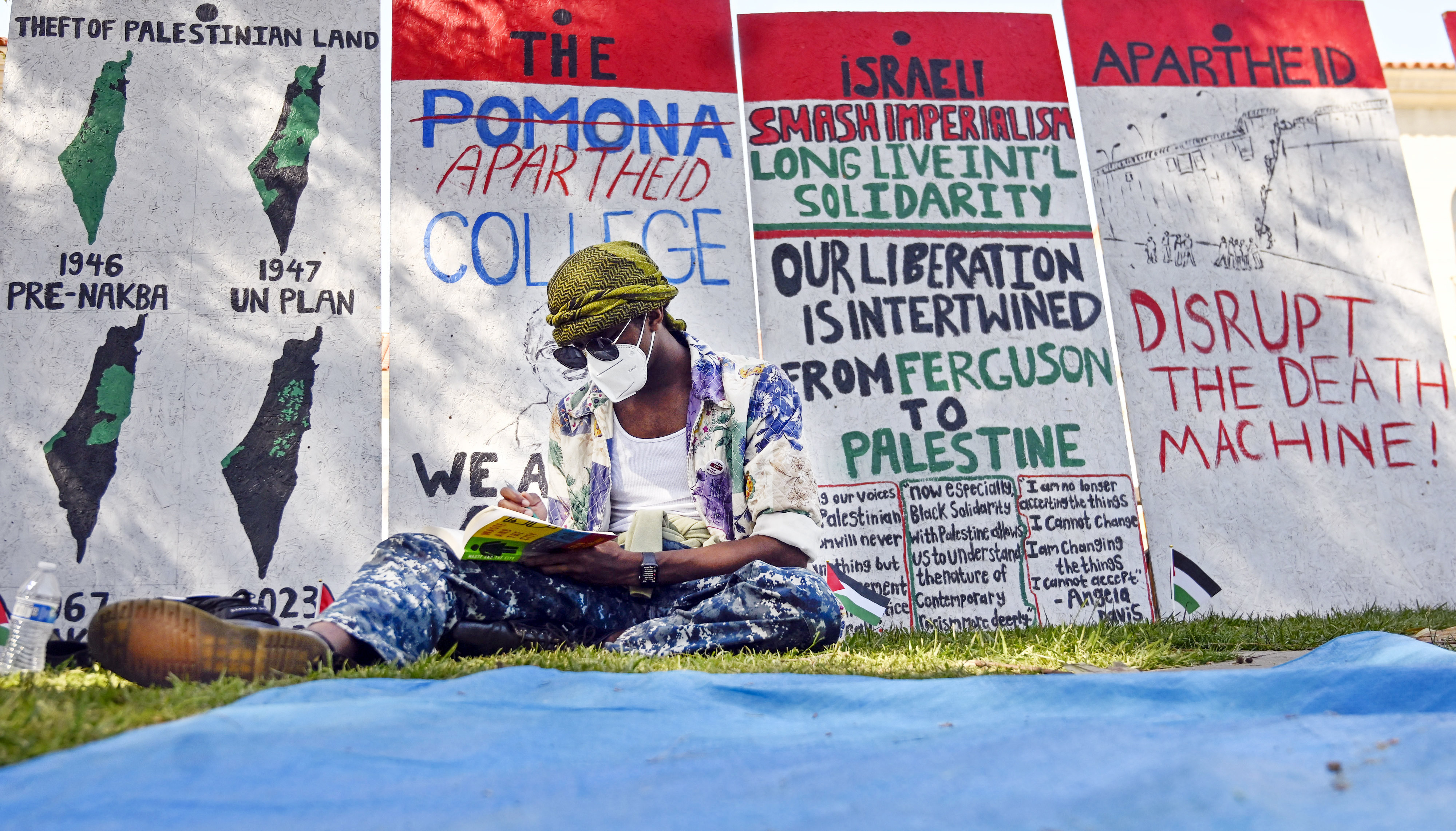 A student protester at Pomona College studies in front of...