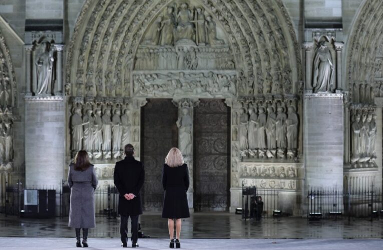 An archbishop’s knock formally restores Notre Dame to life as winds howl and heads of state look on